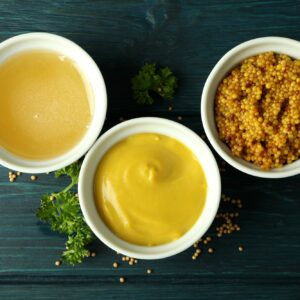 Bowls with sauces on wooden table, top view