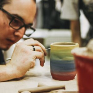 Man painting handcraft mug